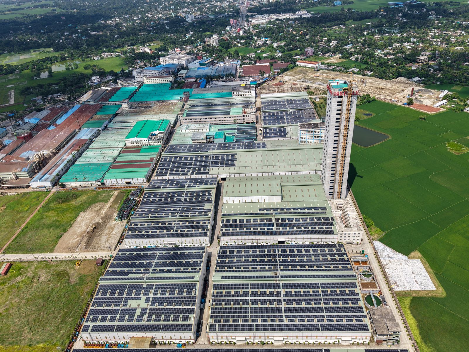 Industrial facility with solar panels and green surroundings